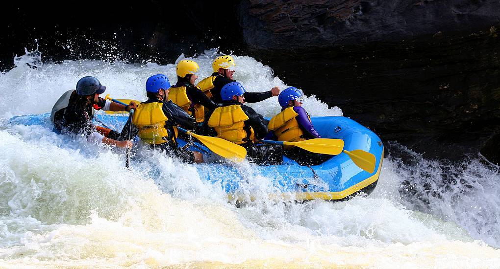 Group of people white water rafting