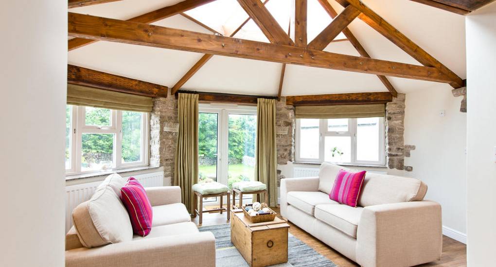 A bright reception room at Peak Star with exposed wooden roof beams and comfortable sofas for hen party groups.