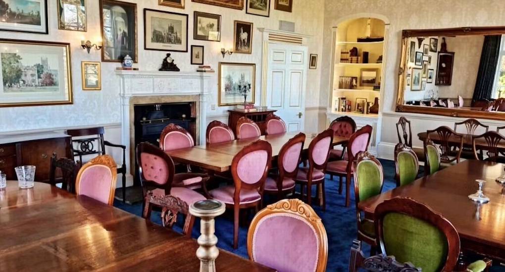 The formal dining room at Rivers Countryside Mansion, with multiple tables and elegant chairs for a large hen party meal.