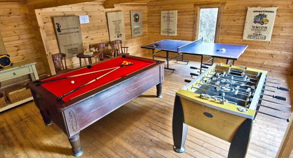 The impressive dedicated games room at Standing Barn Gloucestershire, featuring a pool table, table tennis, and table football, part of the Games Room & Hot Tub entertainment package for the party house.