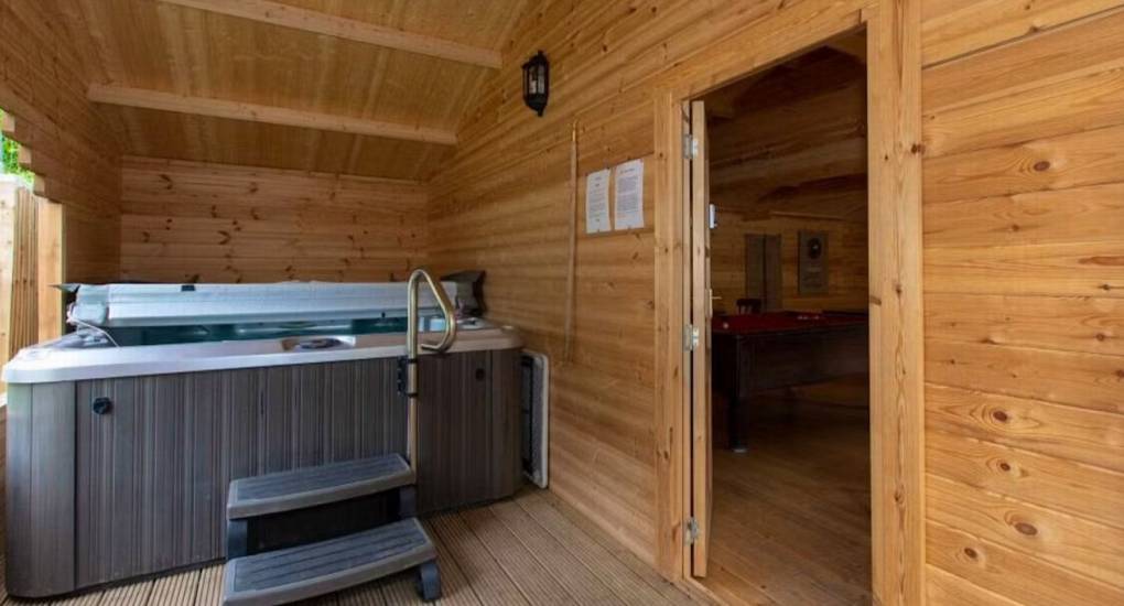 The enclosed indoor/outdoor hot tub at Standing Barn Gloucestershire, located conveniently next to the Games Room for the ultimate Party House experience.